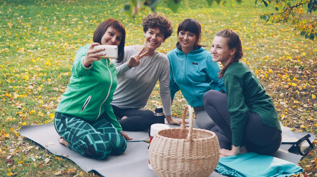 Group of smiling Japanese seniors doing stretching exercises outdoors